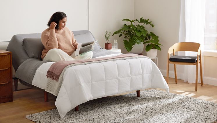 woman laying on mattress studying