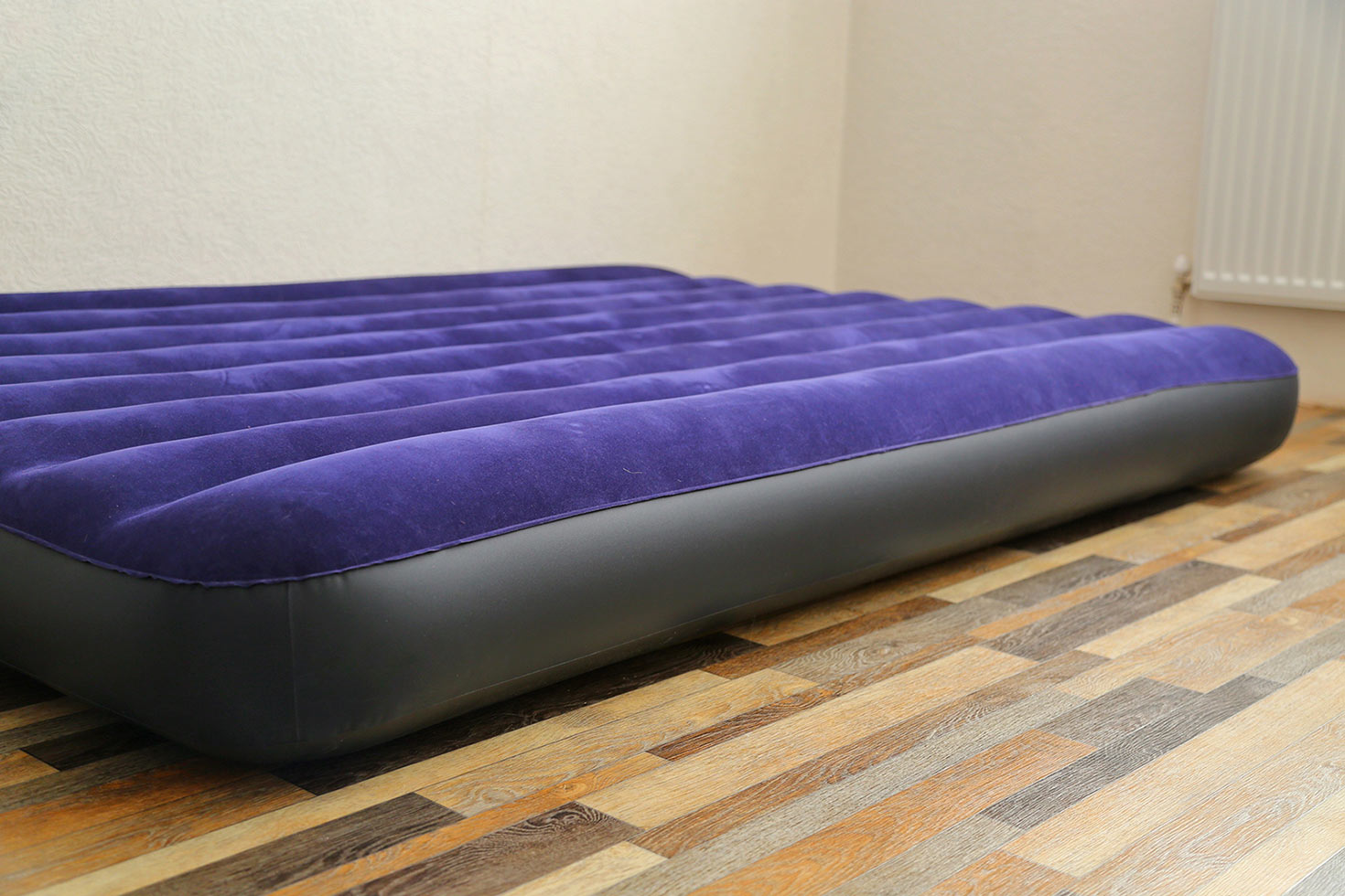 Photo of an inflated air mattress in an empty room.