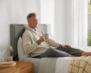 A man lounging on a Purple bed.