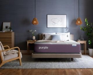 A Purple RestorePlus Hybrid Mattress in a dark bedroom.