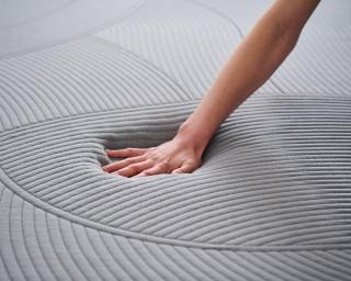 A hand pressing into a Purple RestorePlus mattress.