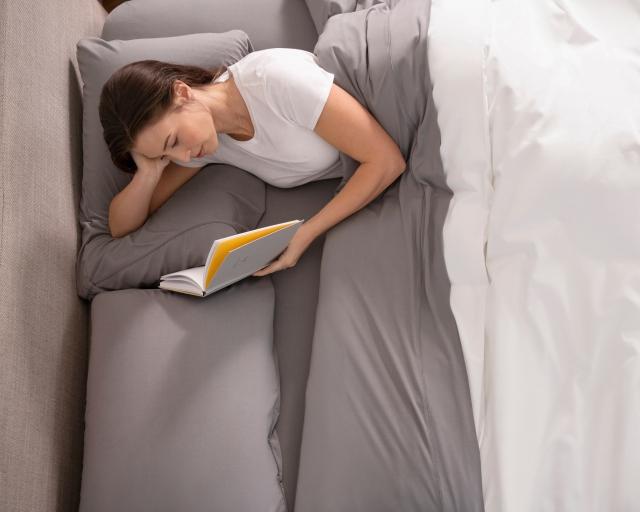 Woman reading using duvet