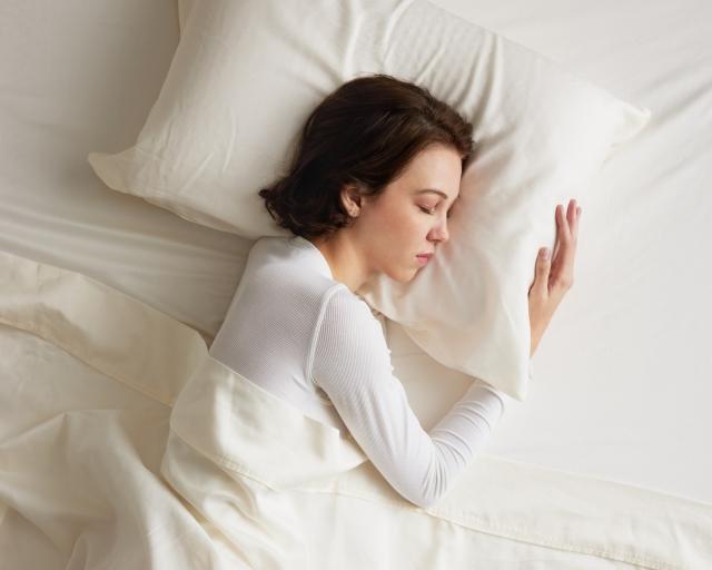 Woman sleeping in white sheets