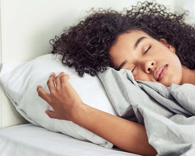 Woman lying asleep in bed.