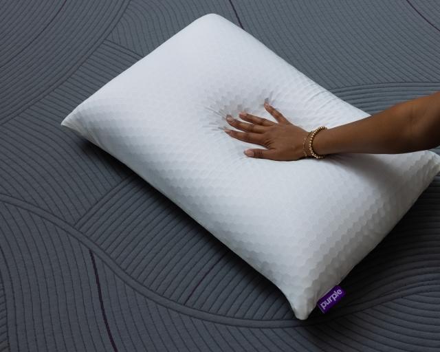 A woman pressing her hand into the Purple Harmony pillow.