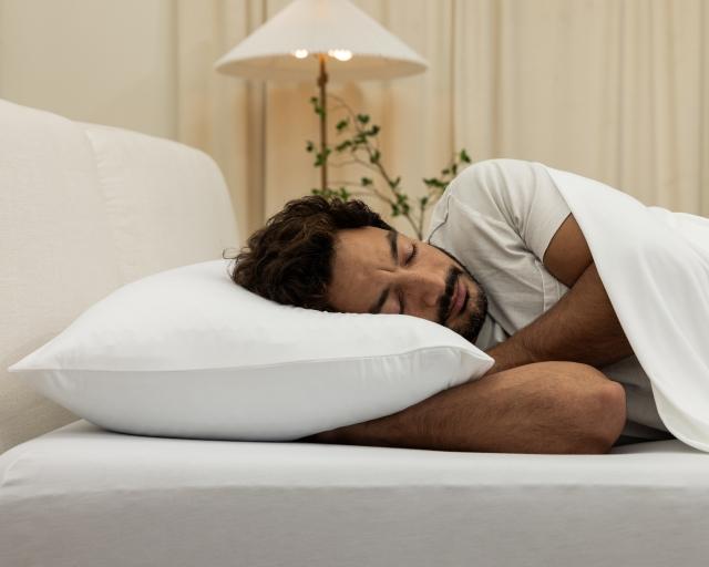 A man sleeping on a Purple Freeform pillow.
