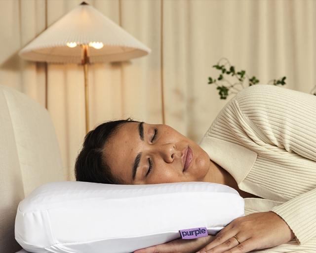 A woman sleeping on a Purple DreamLayer pillow.