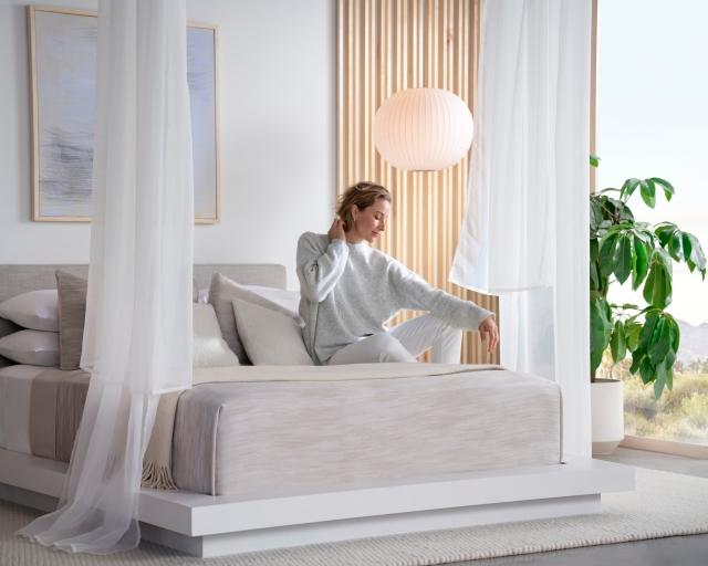 A woman waking up on a Purple Rejuvenate mattress.