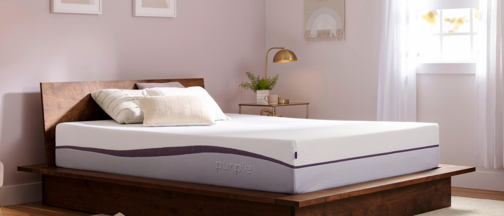 An unmade Purple Plus mattress in a bedroom