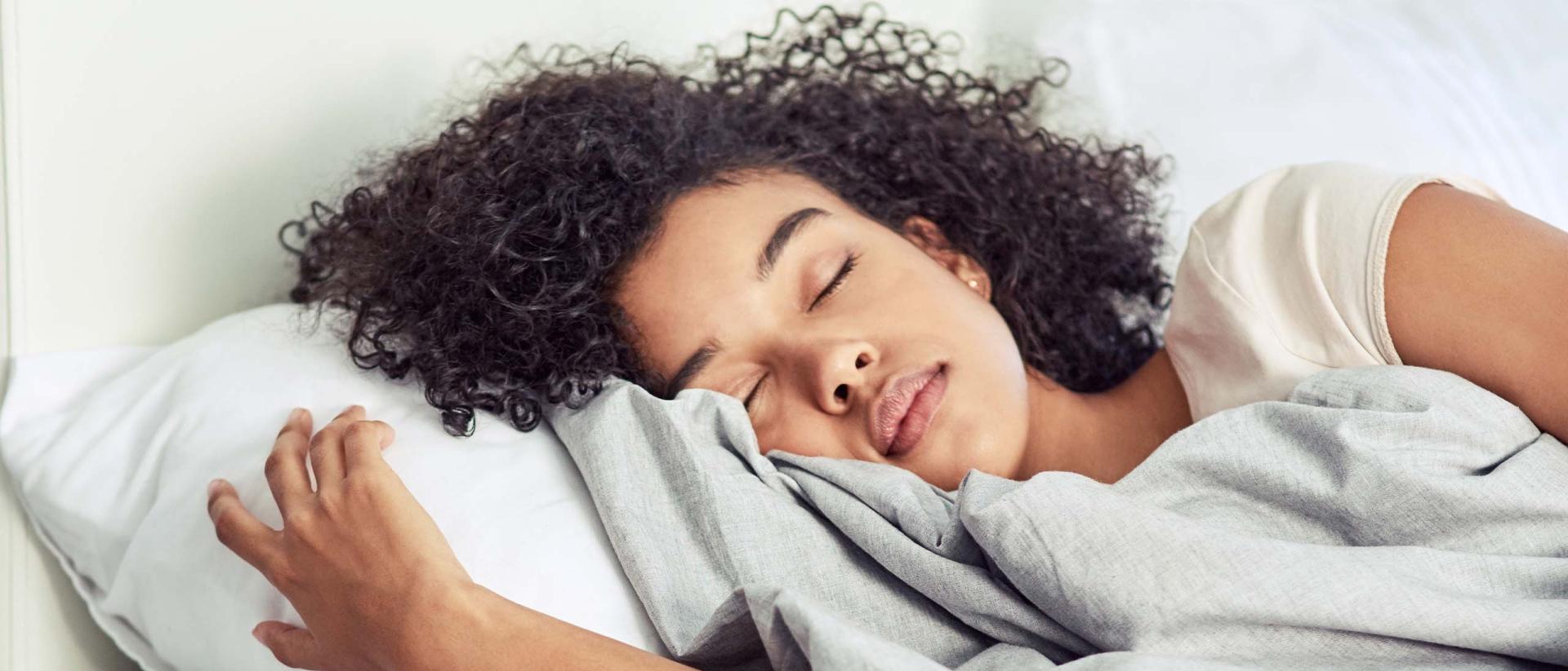 Woman lying asleep in bed.