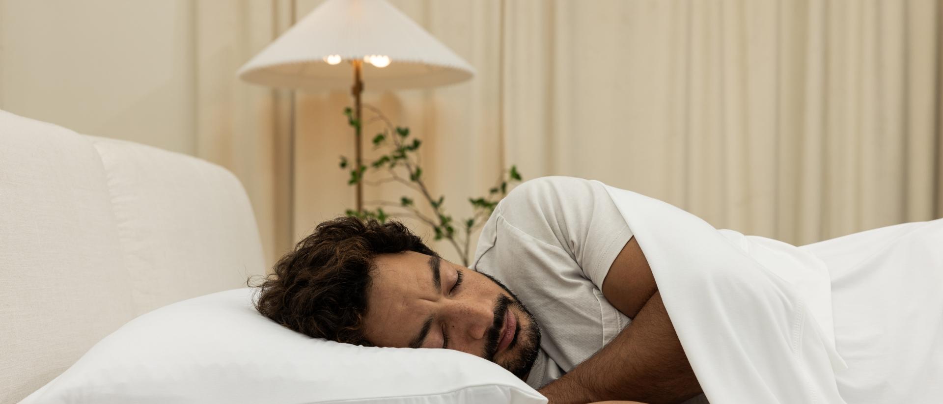 A man sleeping on a Purple Freeform pillow.