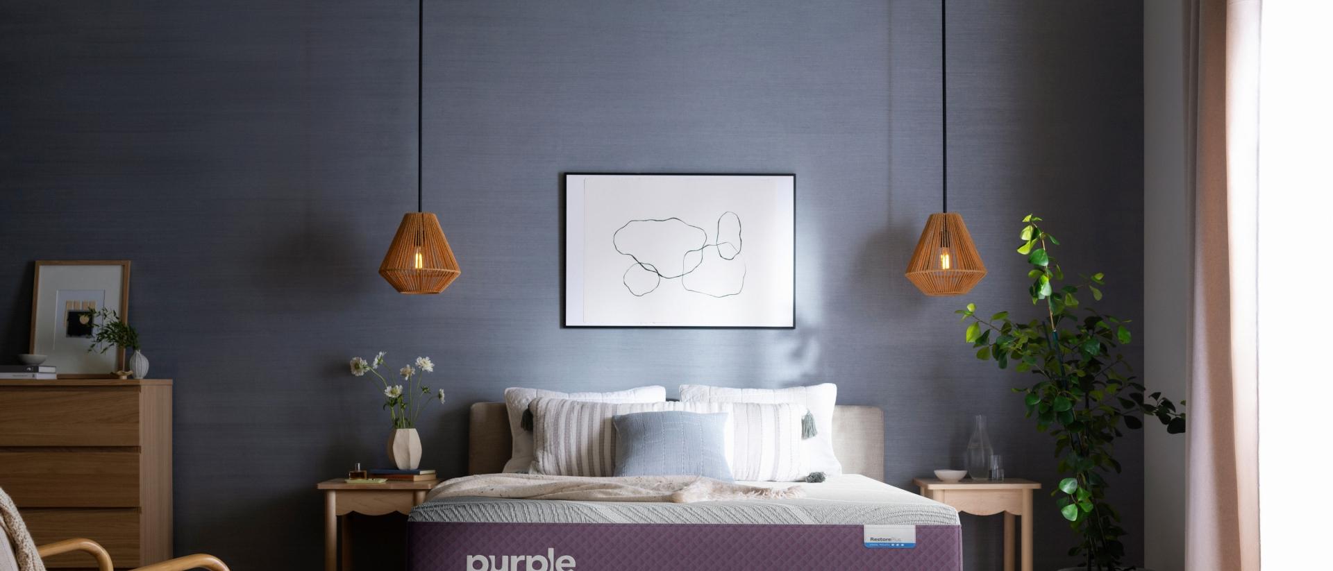 A Purple RestorePlus Hybrid Mattress in a dark bedroom.