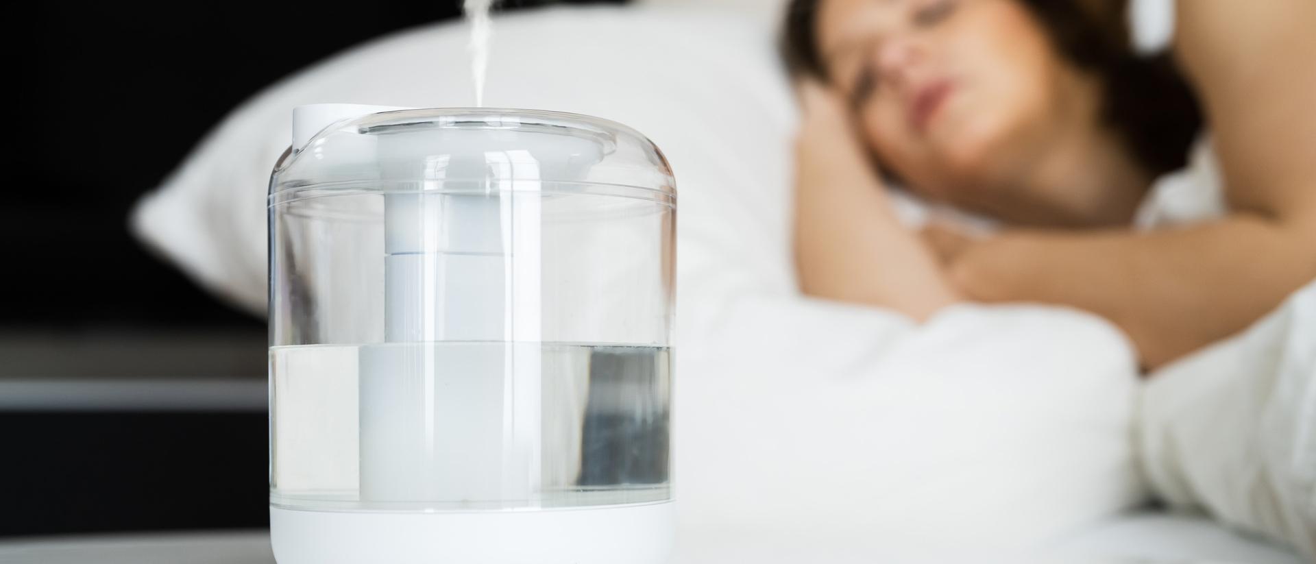 A woman sleeps with a humidifier running in the bedroom.