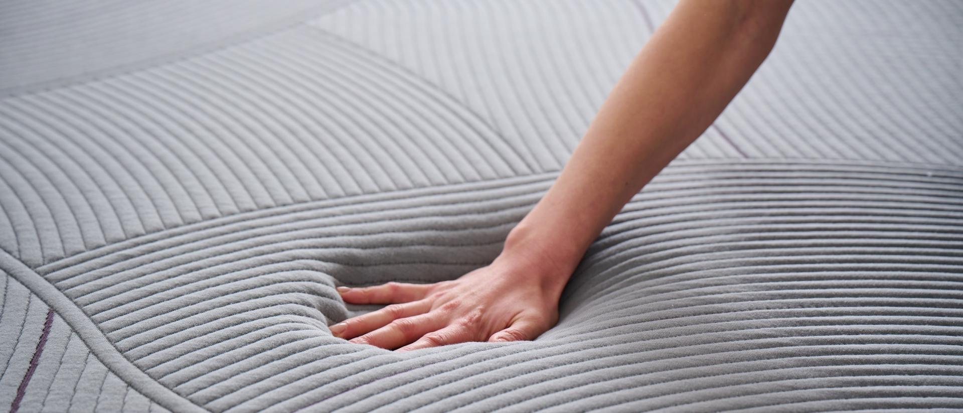 A hand pressing into a Purple RestorePlus mattress.