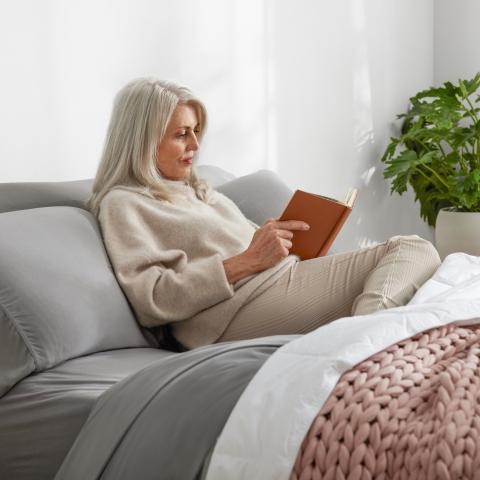 Woman reading a book on Purple Bed Set